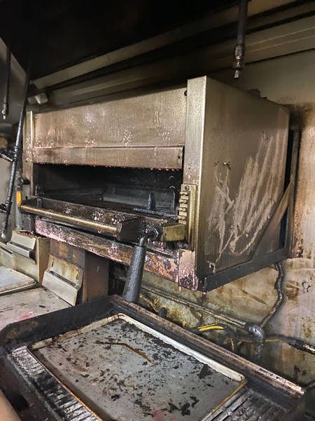 Restaurant broiler with heavy grease and carbon buildup before cleaning