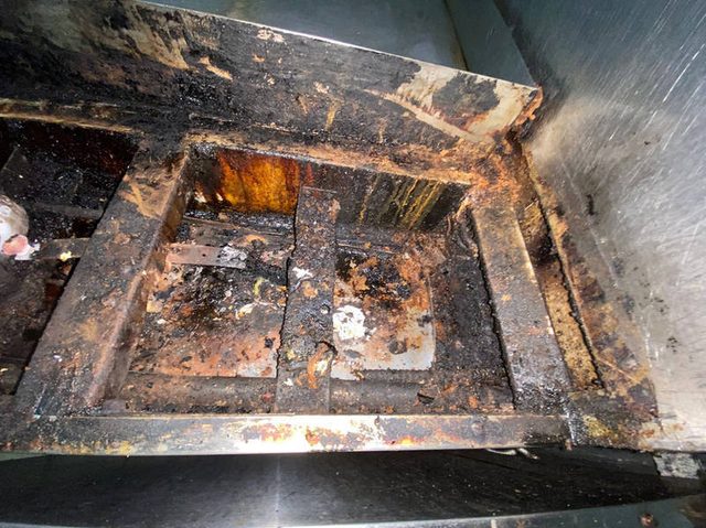 Fryer cabinet interior caked with burnt grease before cleaning
