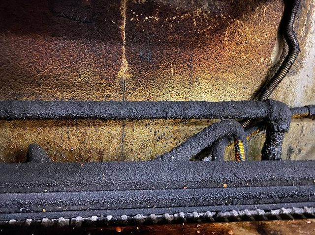 Grill grates and burners coated in carbon before cleaning