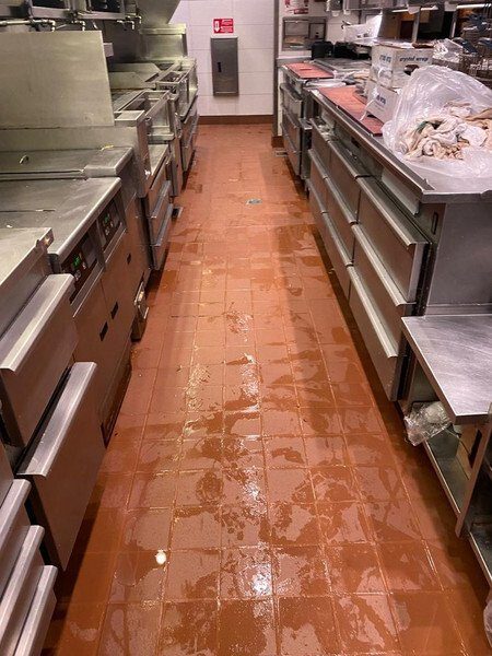 Restaurant kitchen aisle floor during wet cleaning